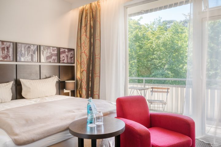 Doppelzimmer mit rotem Sessel, Sitzecke und Balkon
