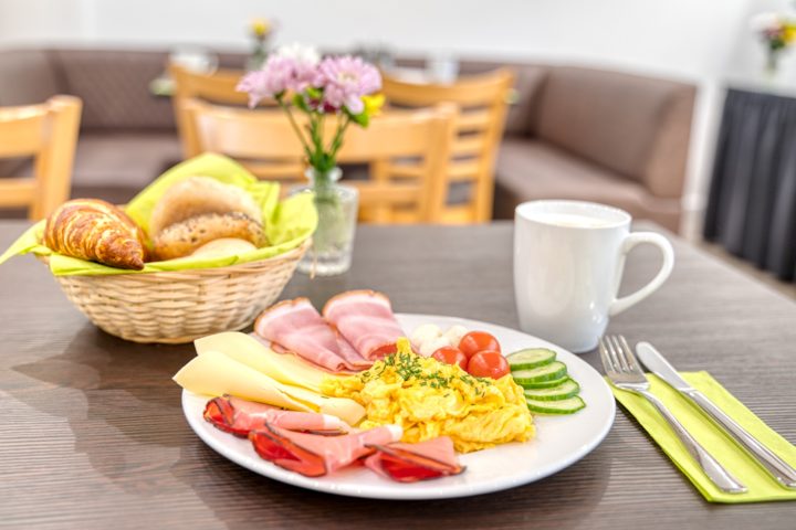 Frühstück mit Rührei, Käse, Aufschnitt, Brötchen und Kaffee