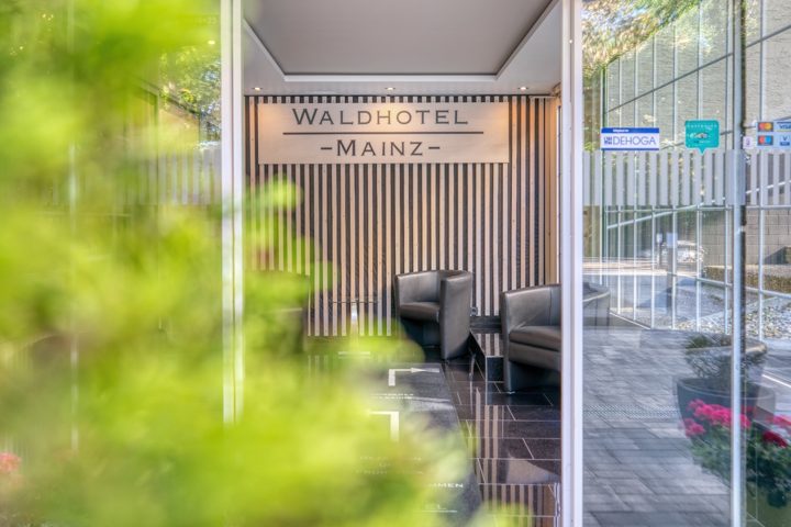 Eingangsbereich mit Waldhotel-Mainz-Schriftzug und Holzlamellen