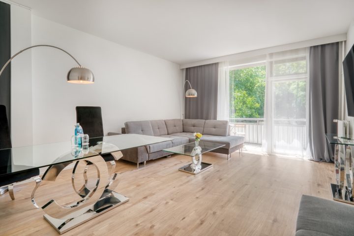Wohnbereich der Suite mit Sofa, Tisch und Balkonzugang