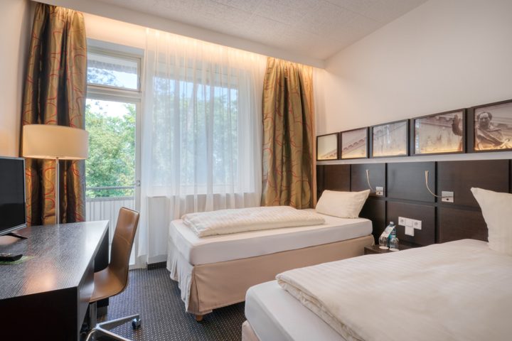 Zweibettzimmer mit zwei getrennten Betten und Blick ins Grüne